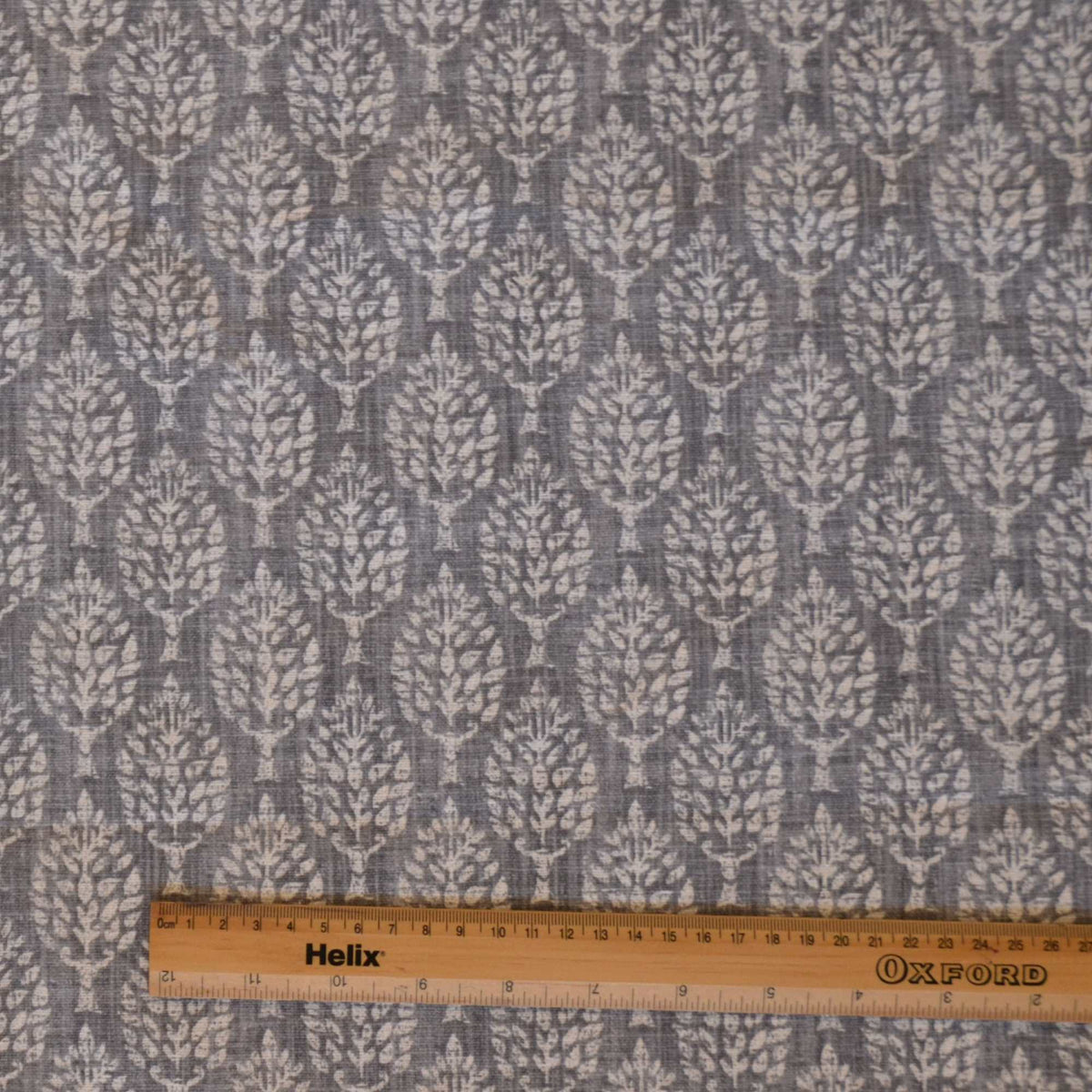 Leaf print fabric in grey with rule for scale