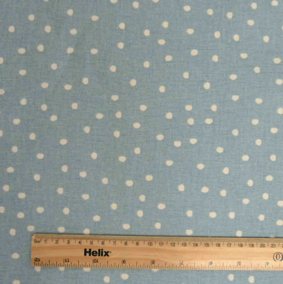 Cotton curtain fabric ocean blue with a spot design and a rule for scale