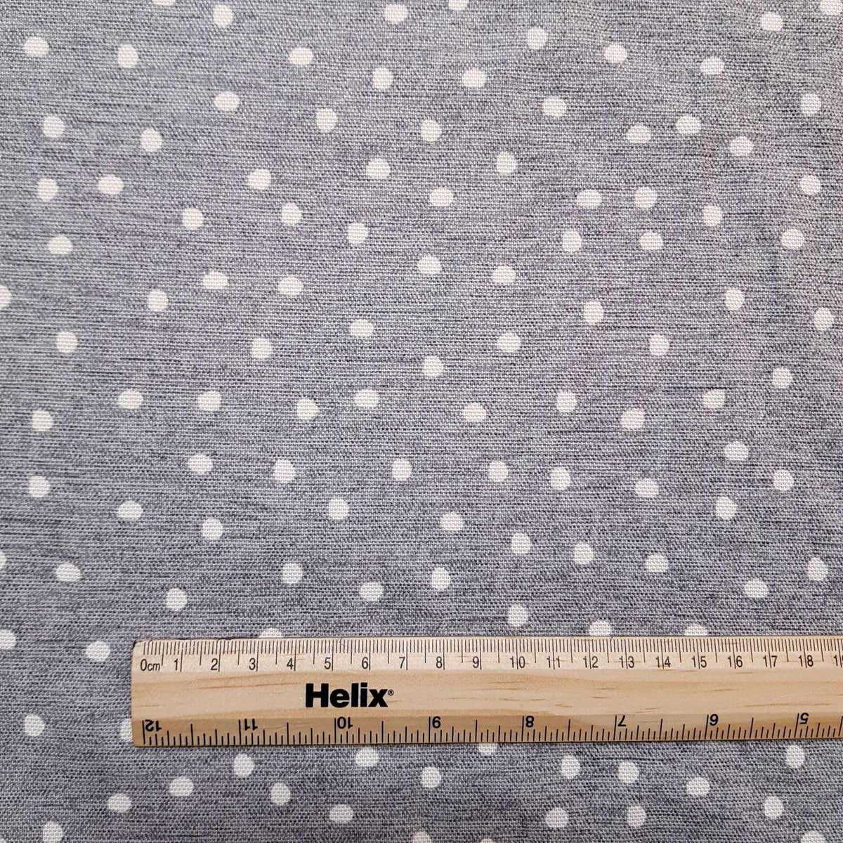 Cotton curtain fabric pewter grey with a spot design and a rule for scale