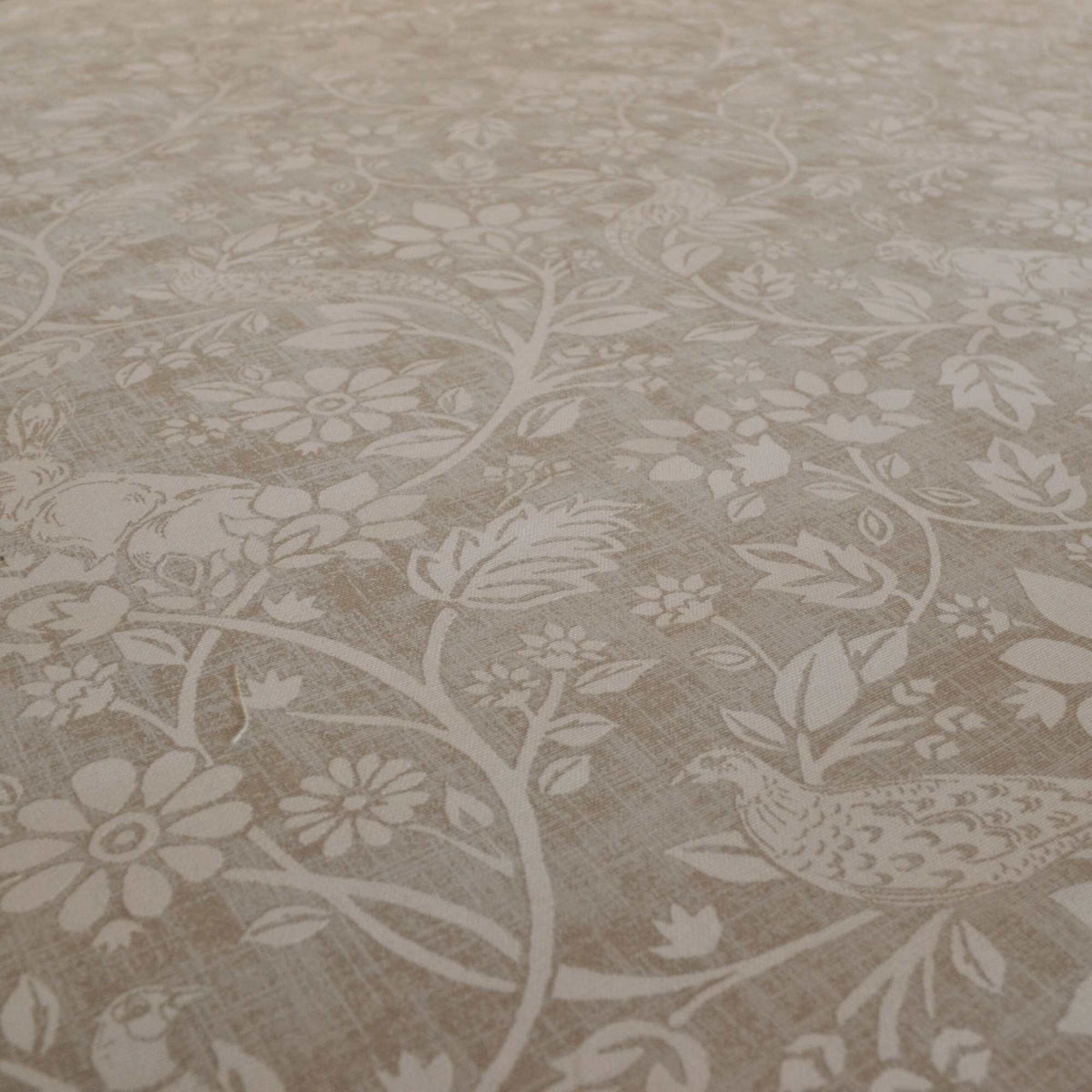 Printed curtain fabric with a design of hares and pheasants in cream on a beige background