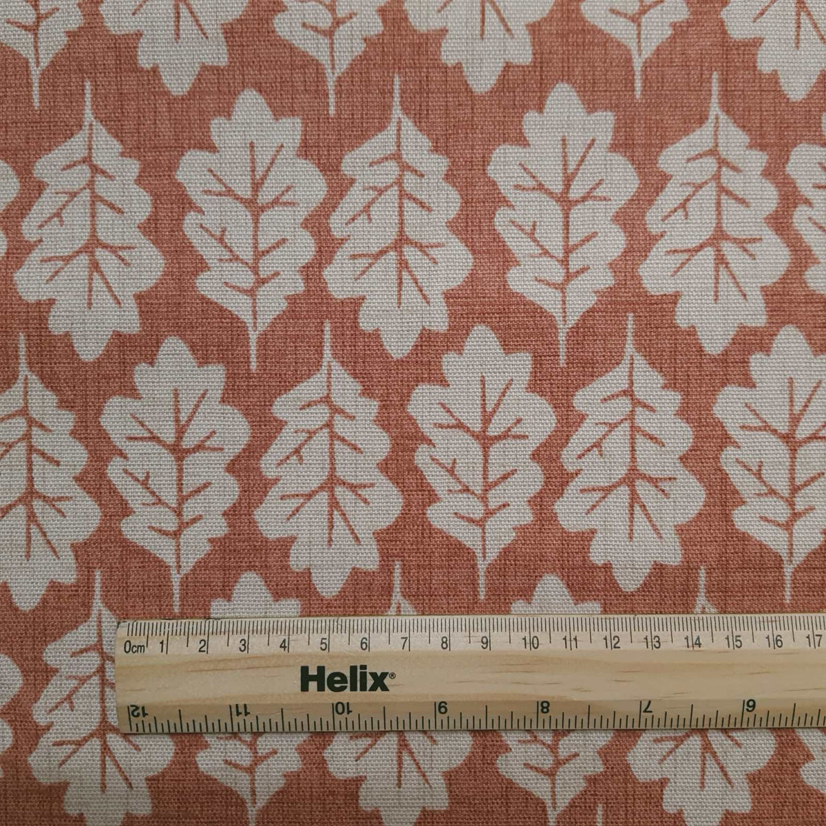 Leaf print fabric in terracotta with rule for scale