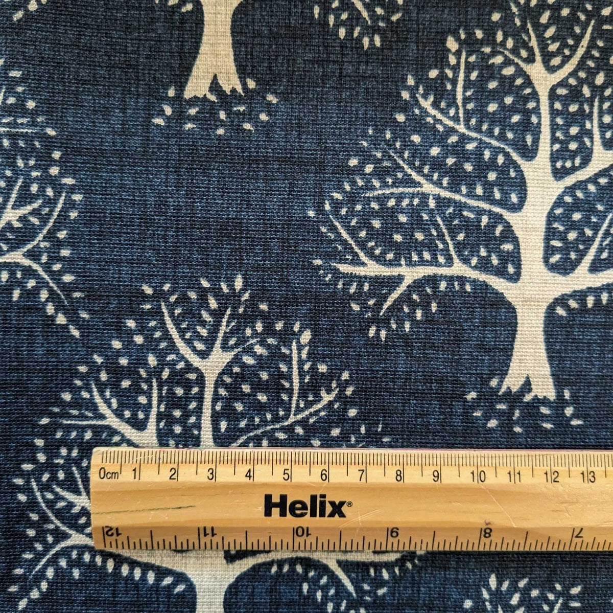 Navy BlueFabric with a print of oak trees and and a rule for scale