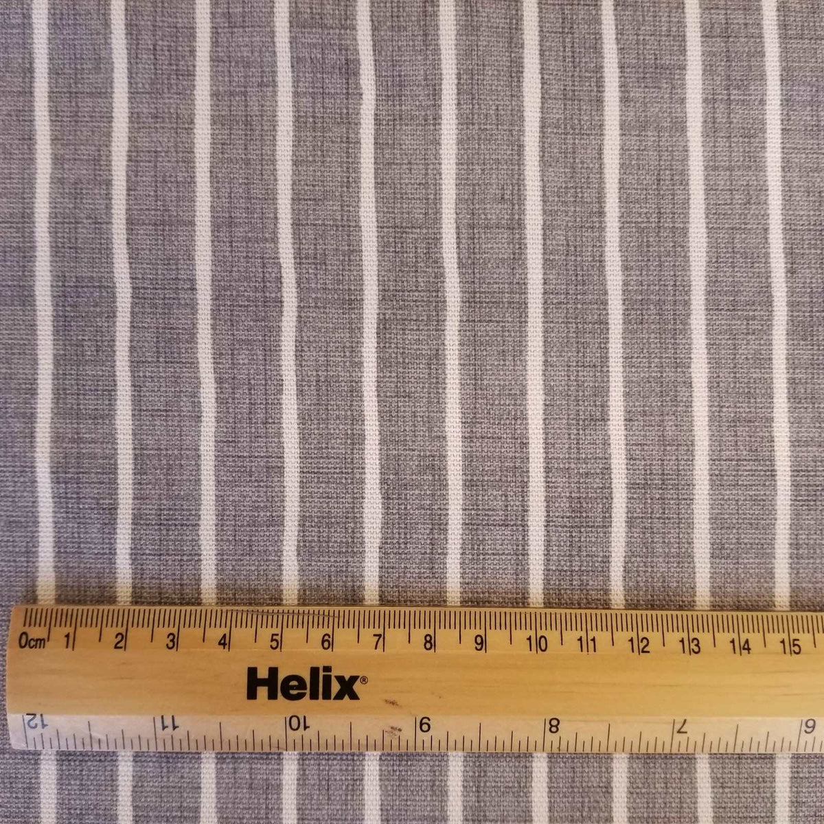 Pewter grey colour curtain fabric with a rule showing size of off white stripes
